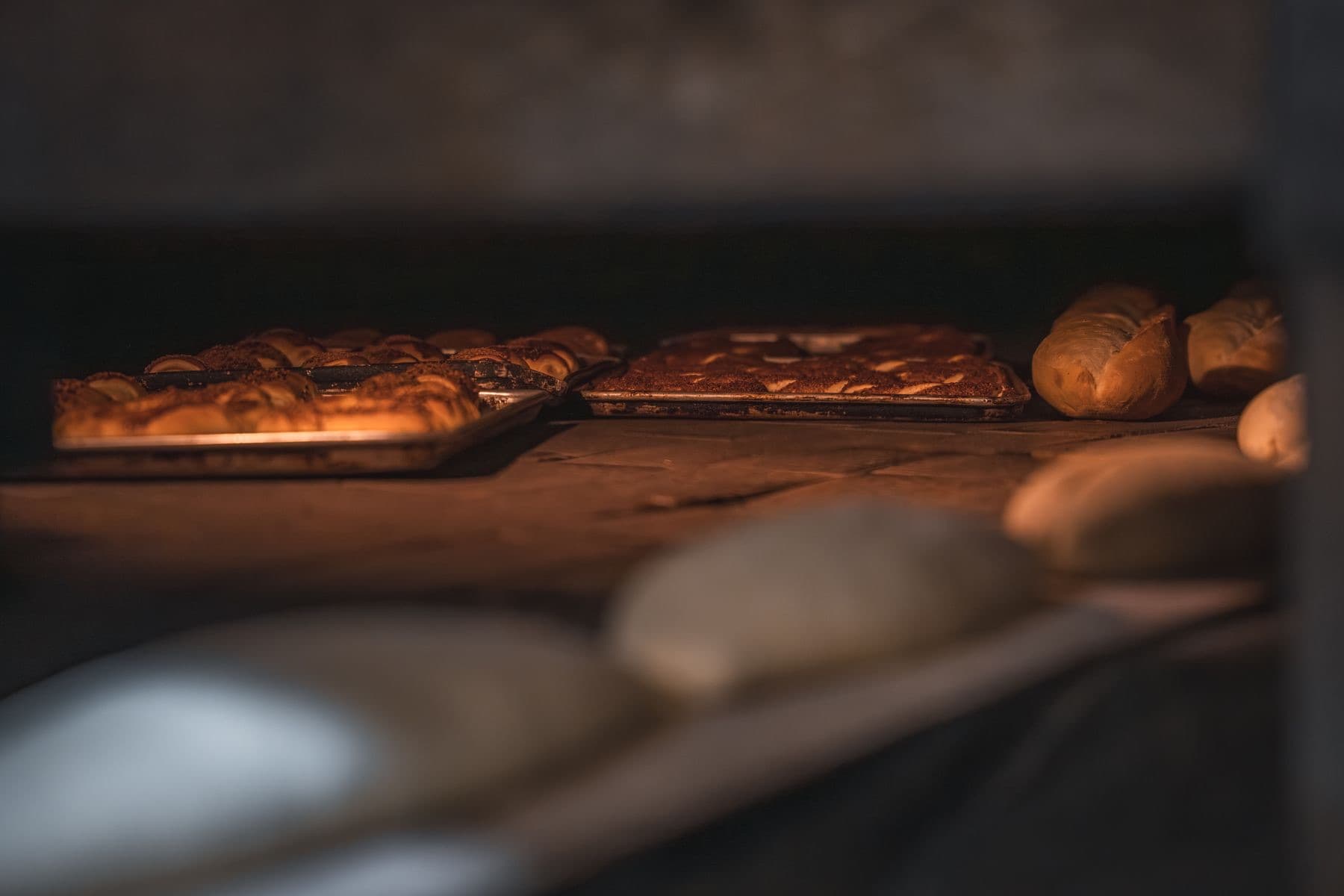 Trays of bread and pastries baking in a warm oven