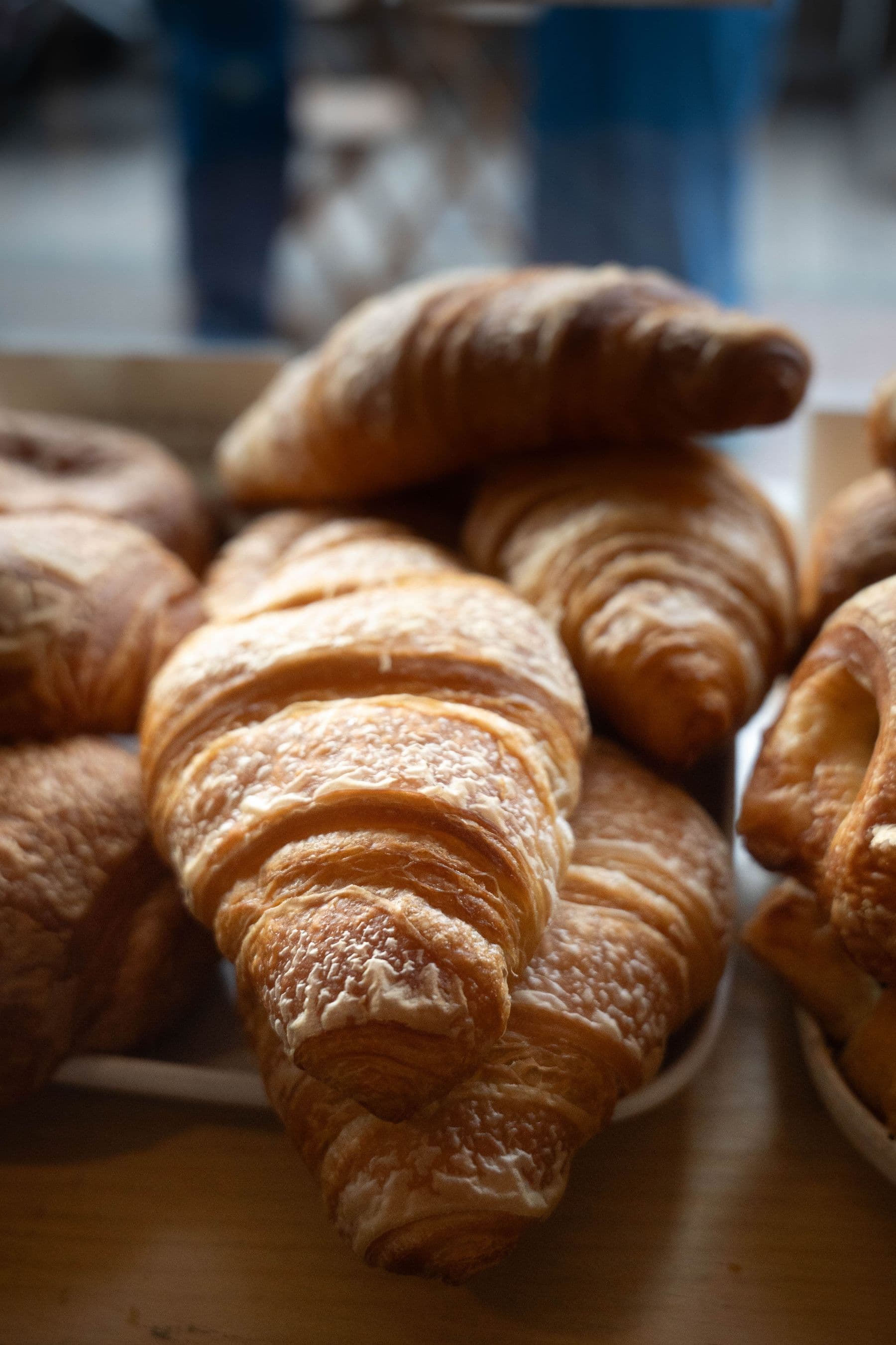 Golden laminated croissants stacked in a bakery display