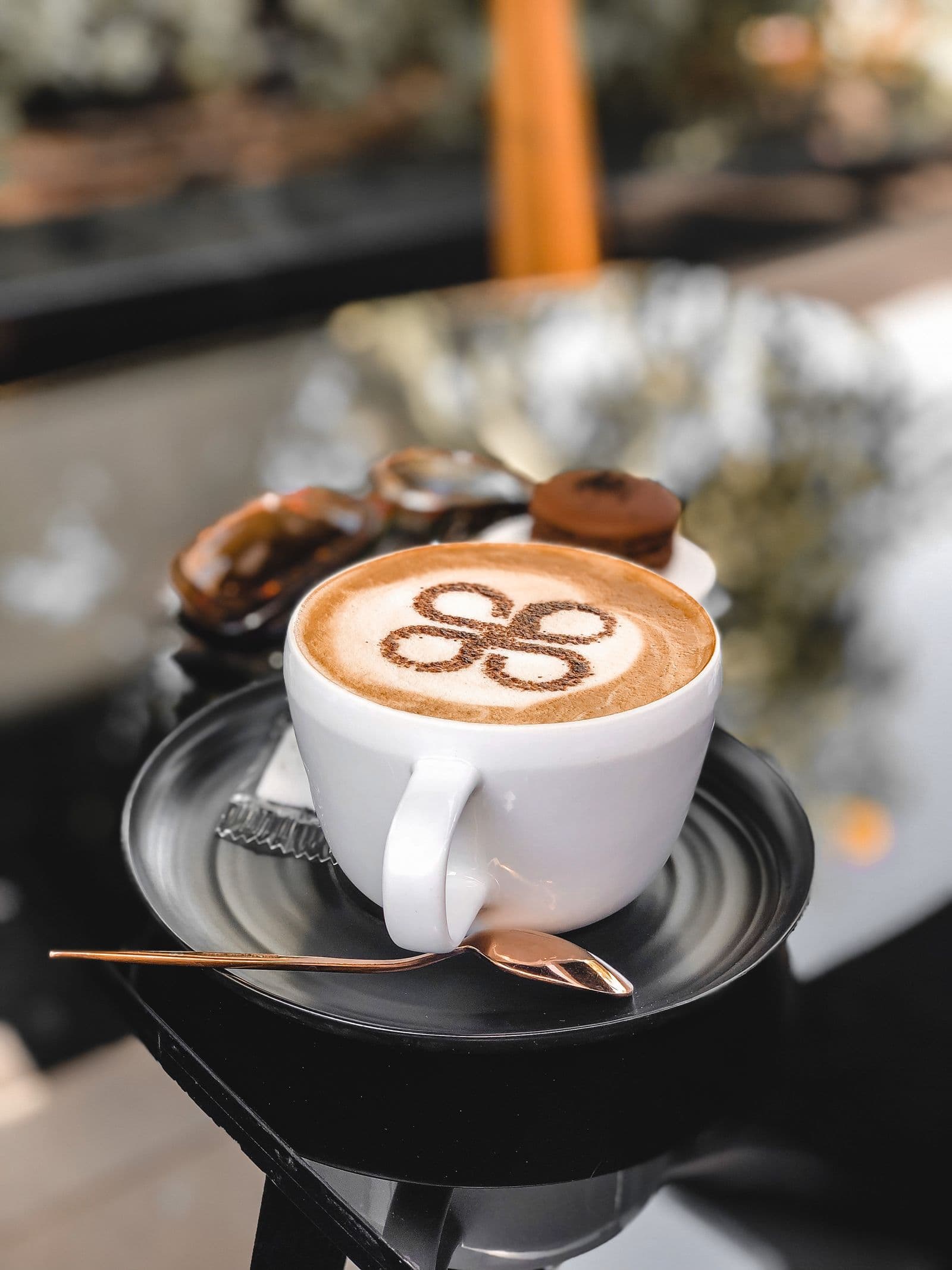 A cappuccino poured with latte art, resting on a saucer